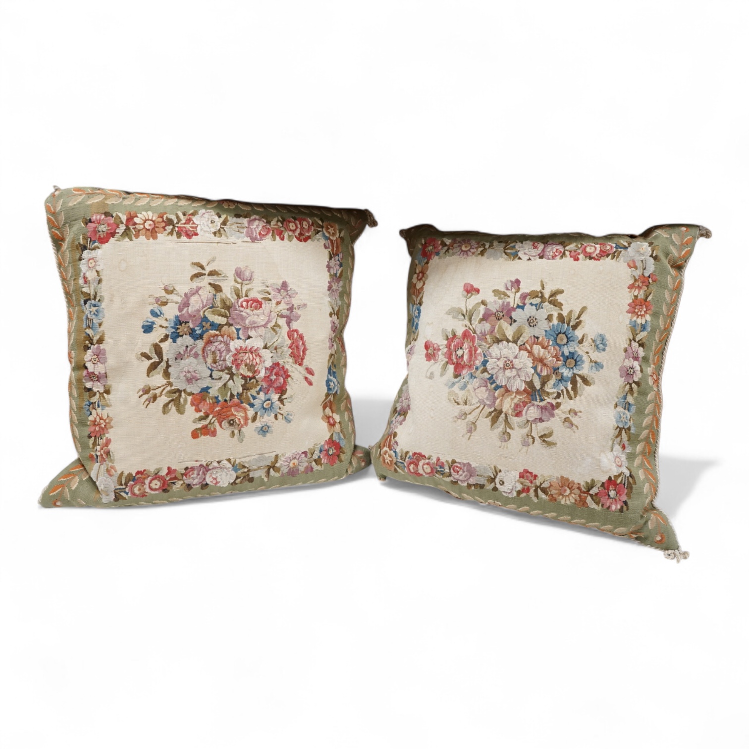 A large pair of 20th century Aubusson floral tapestry cushions. Woven with a central cartouche of roses and garden flowers within a floral border, green band of stylistic leaf design. Finished with cording and backed wit